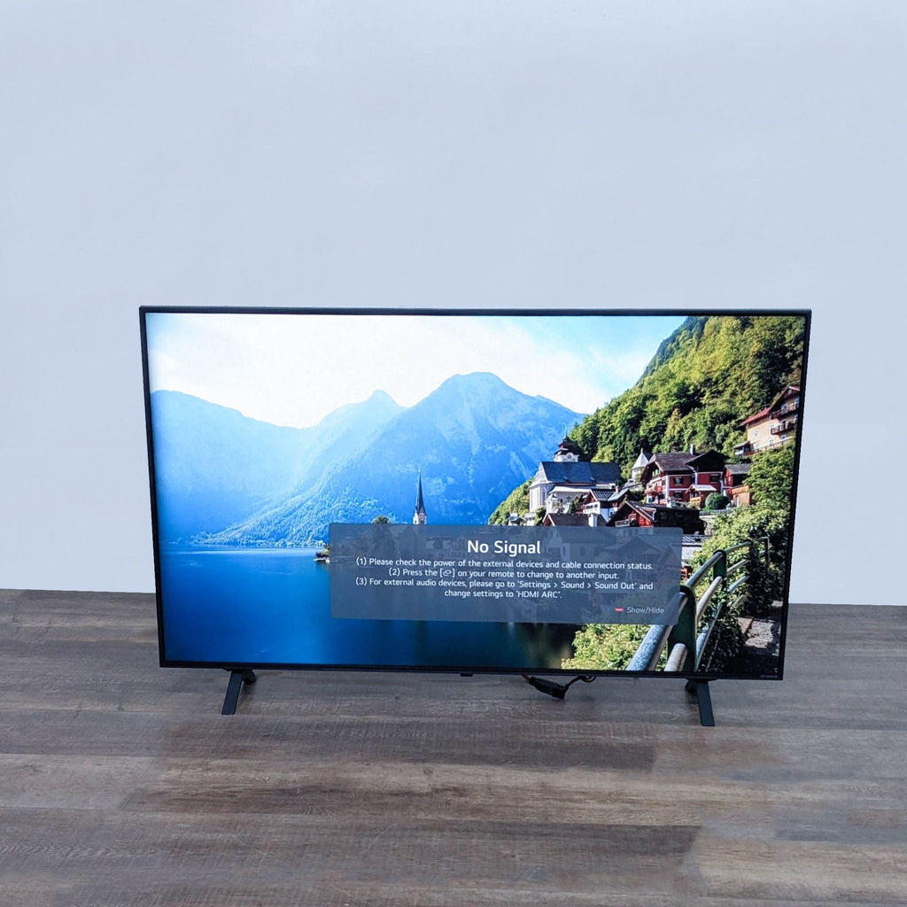 LG TV displaying "No Signal" message over a scenic image.