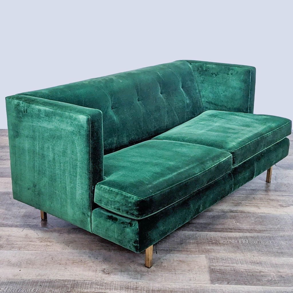 Side view of green loveseat with tufted back and brass accents.