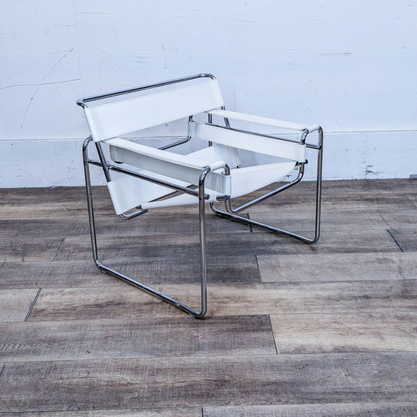 Modern chair with a chrome-finished tubular steel frame and white leather seating, on a wooden floor.