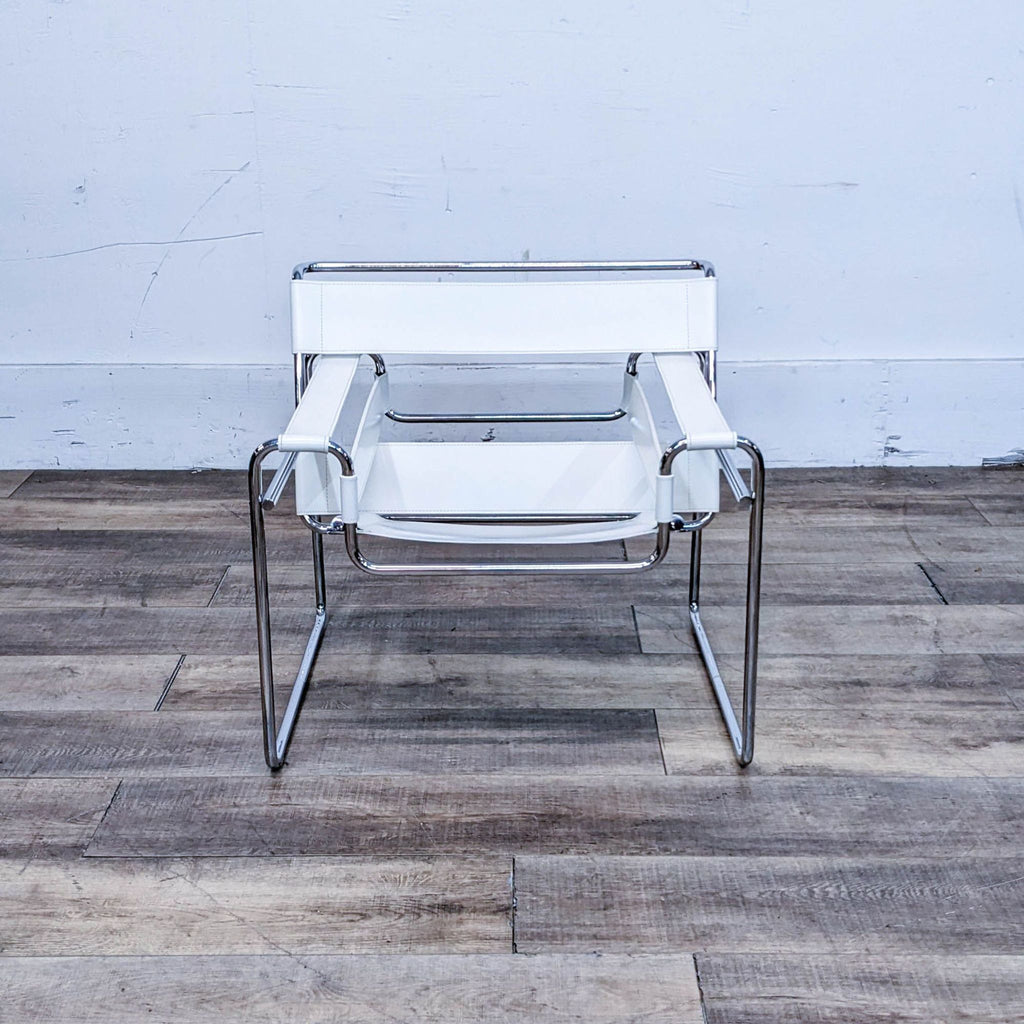 Front view of a contemporary chair with a seamless chrome frame and white leather, situated on a wooden floor.
