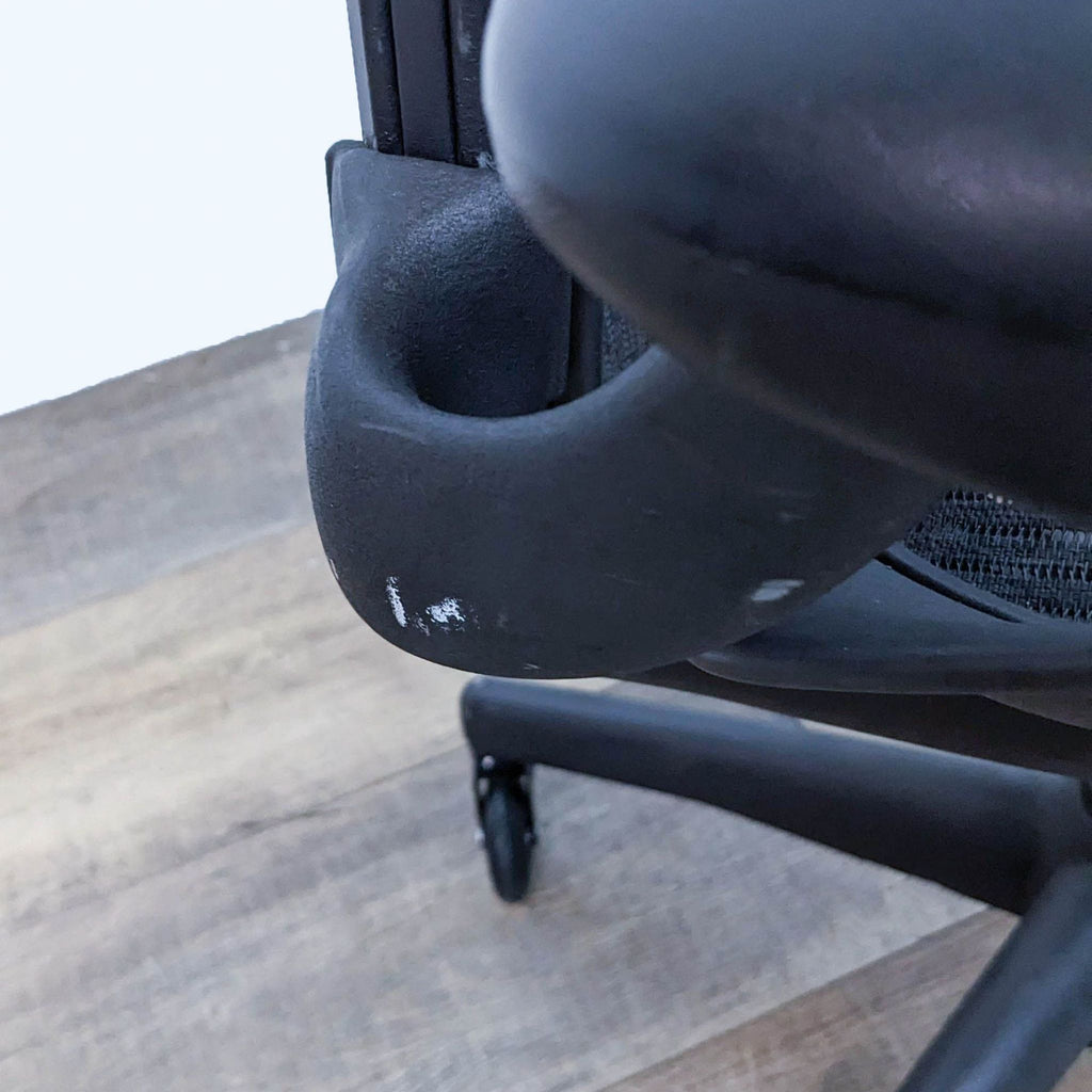 Close-up of the Aeron chair’s armrest with minor scuff.