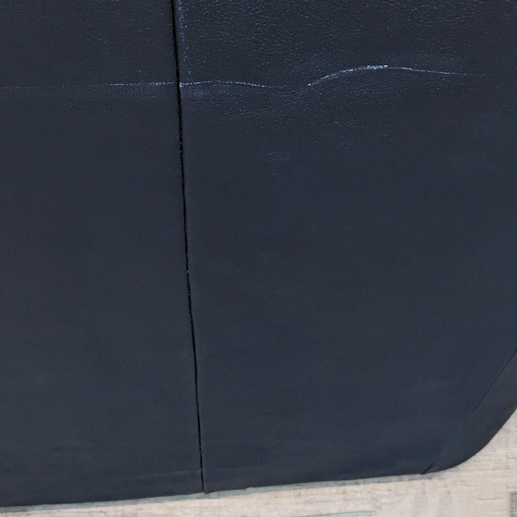 Close-up of black leather texture on Reperch sofa.