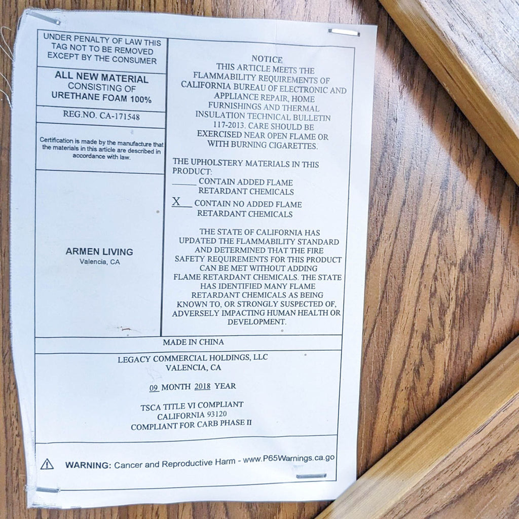 Close-up of the Armen Living chair's label detailing materials and safety compliance.