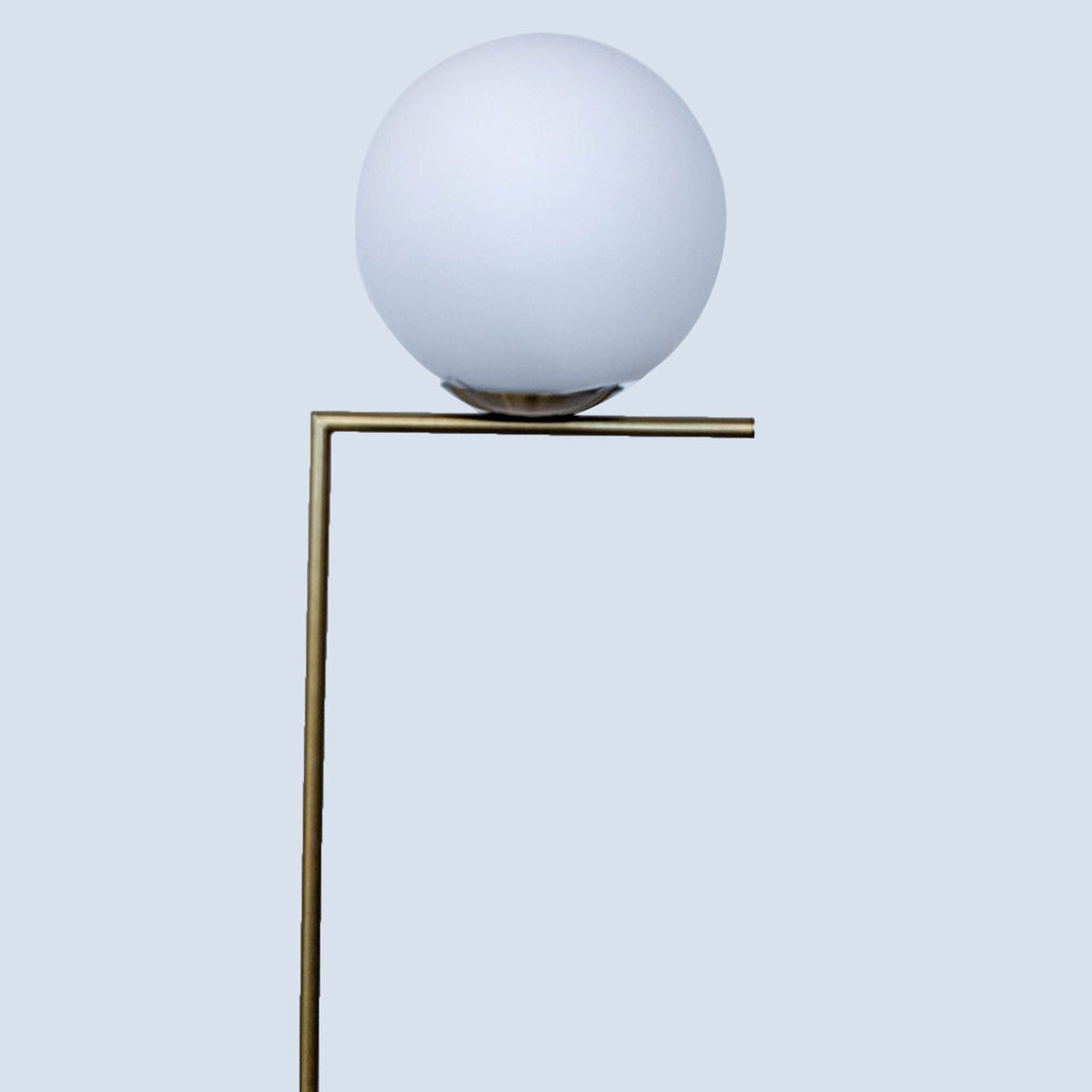 Close-up of Reperch lamp's globe atop an L-shaped brass stand.  