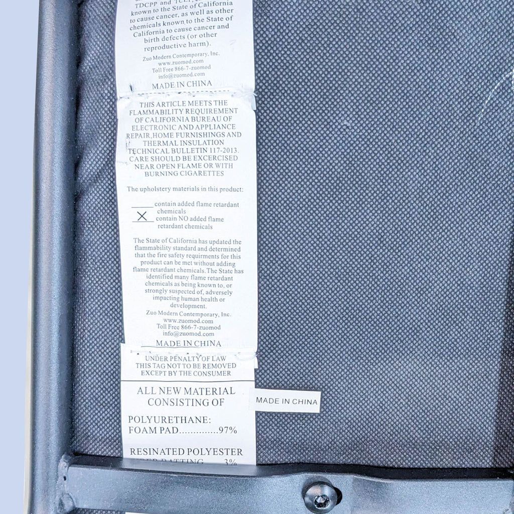 Close-up of label on Zuo Modern chair, detailing materials and manufacturing info.
