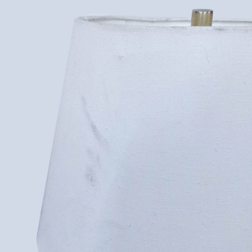 Close-up of white lamp shade with subtle texture and soft lighting effect.