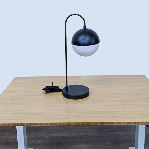 Modern black and white table lamp by Safavieh with a rounded design.