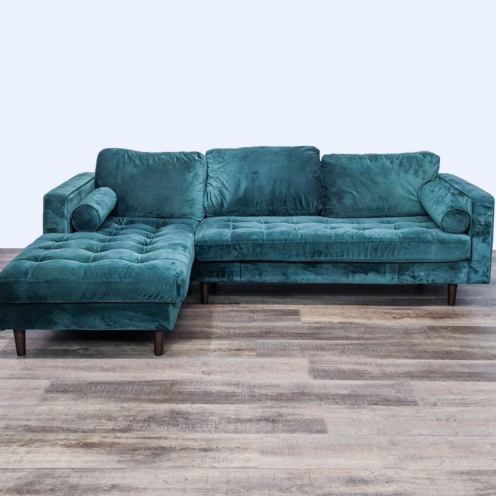 Green velvet tufted sectional with chaise, narrow arms, and tapered feet.