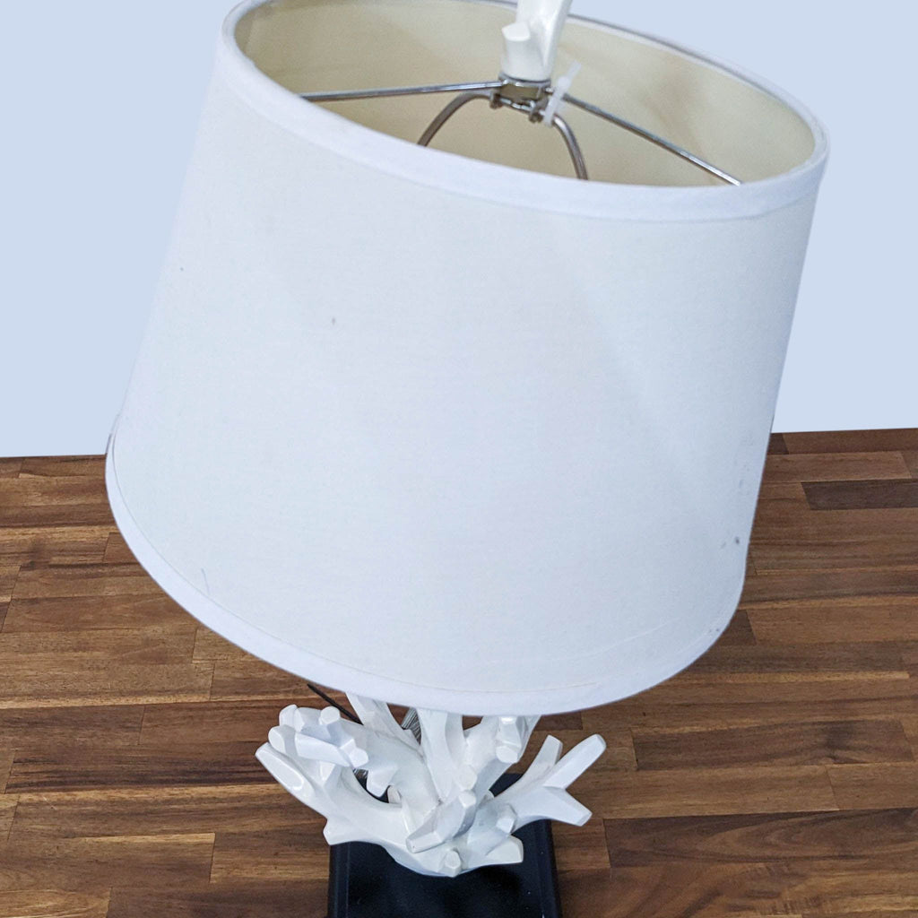 Close-up of Reperch lamp showing the white angled shade and intricate base design.