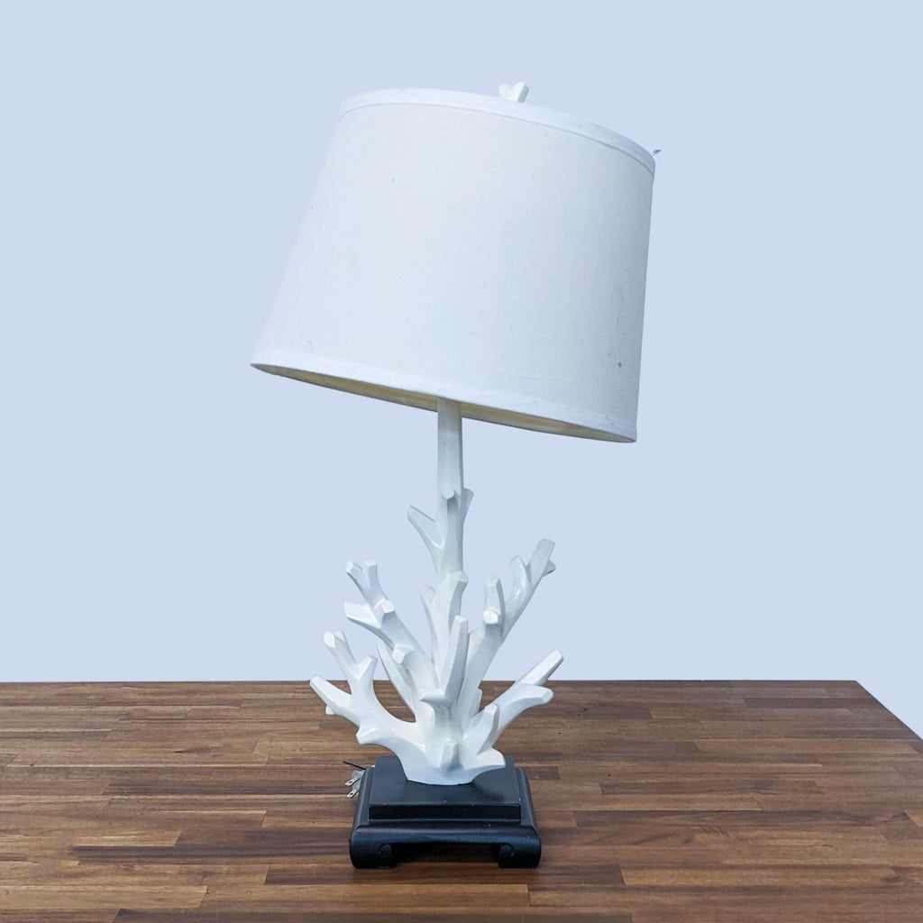 Reperch table lamp with white shade and coral-inspired base on wooden surface.