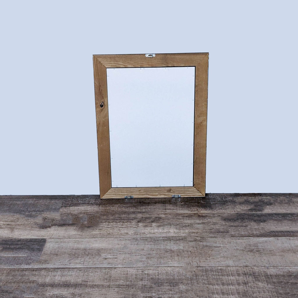 Back view of a wall mirror with a natural wood frame, highlighting the mounting hardware.
