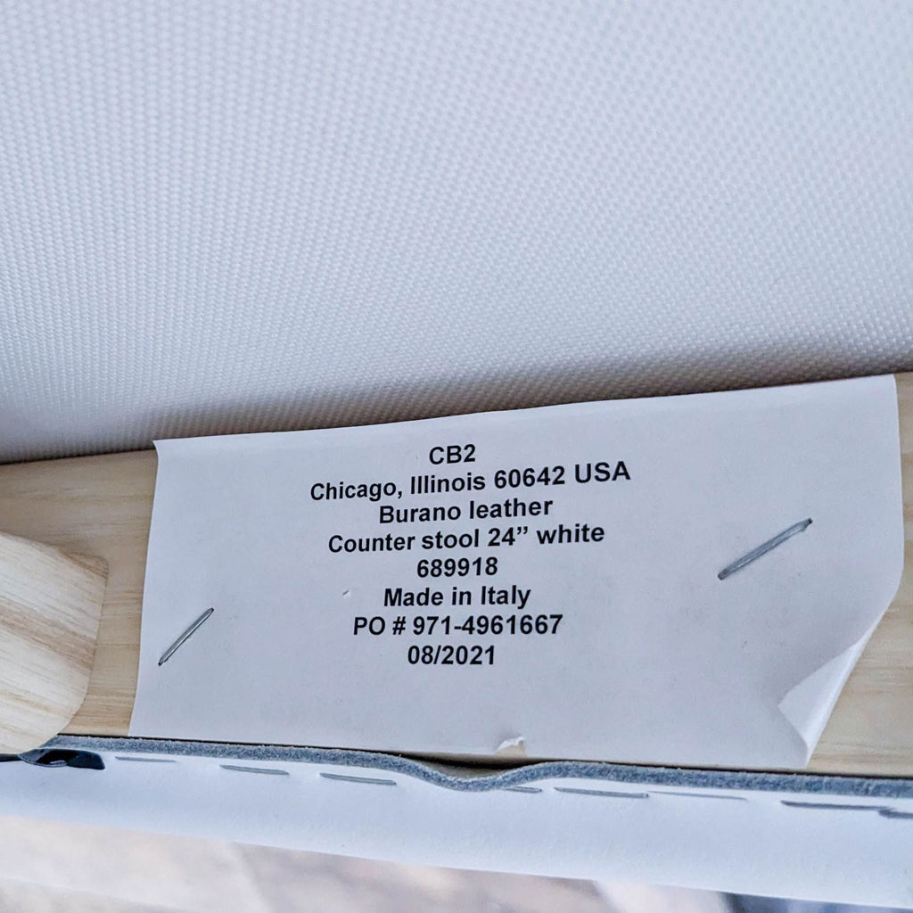 Close-up of stool label detailing brand and materials.