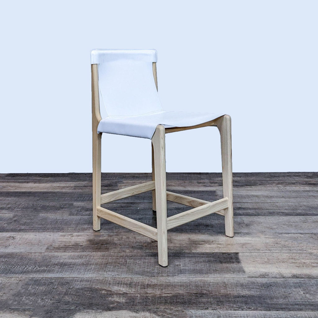 Side angle of white leather stool on ashwood frame.