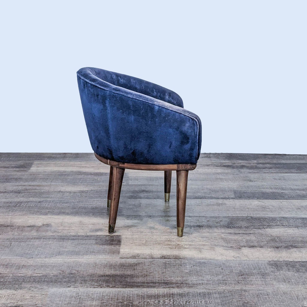 Side view of Viceroy chair with curved sapphire velvet and elegant shesham wood base.