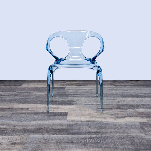 Front view of the AVA chair in sky blue polycarbonate on a wooden floor.