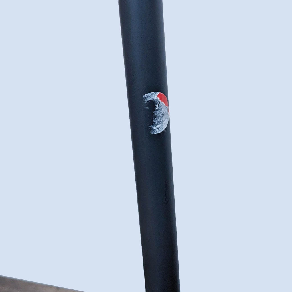 Black lamp pole with small, worn decorative sticker.