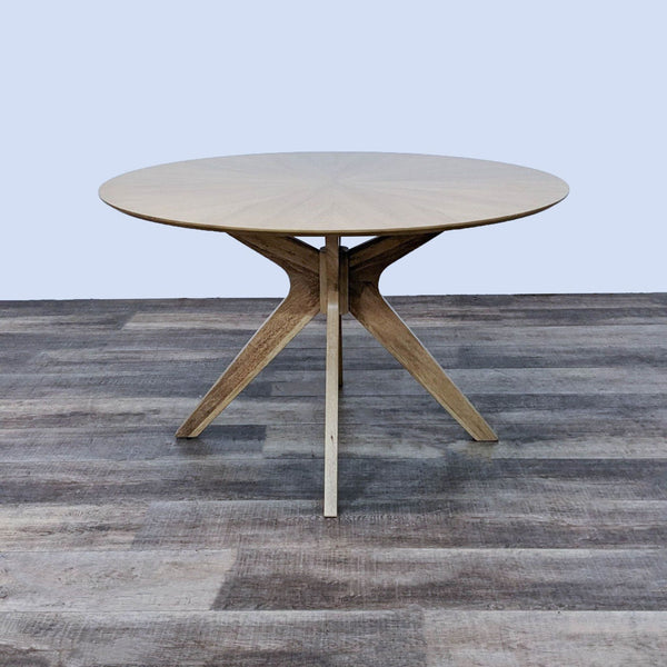 Reperch dining table with a sunburst-patterned top and boomerang-shaped legs.