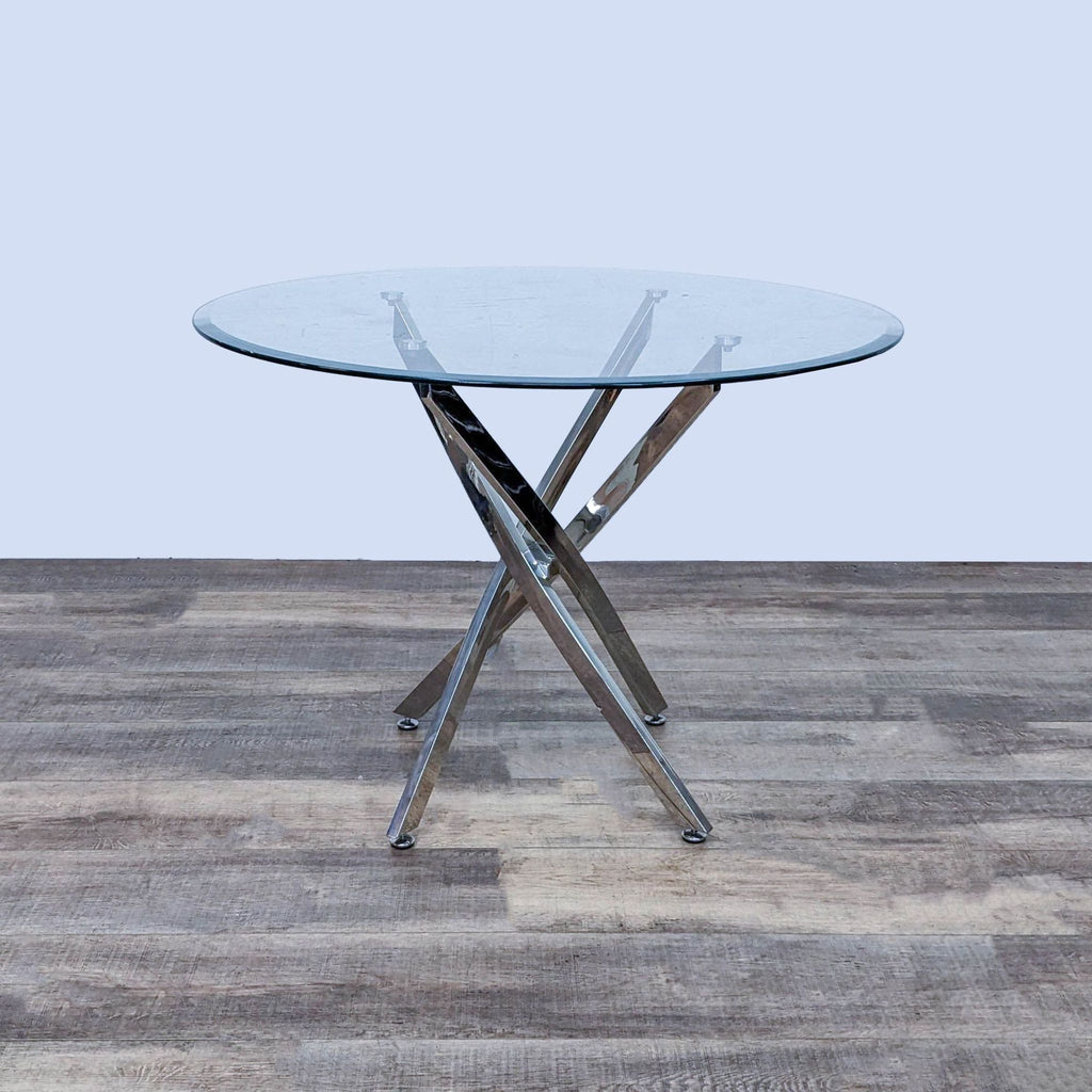 Modern dining table with a chrome base and clear glass top, featuring four angular slanted posts.