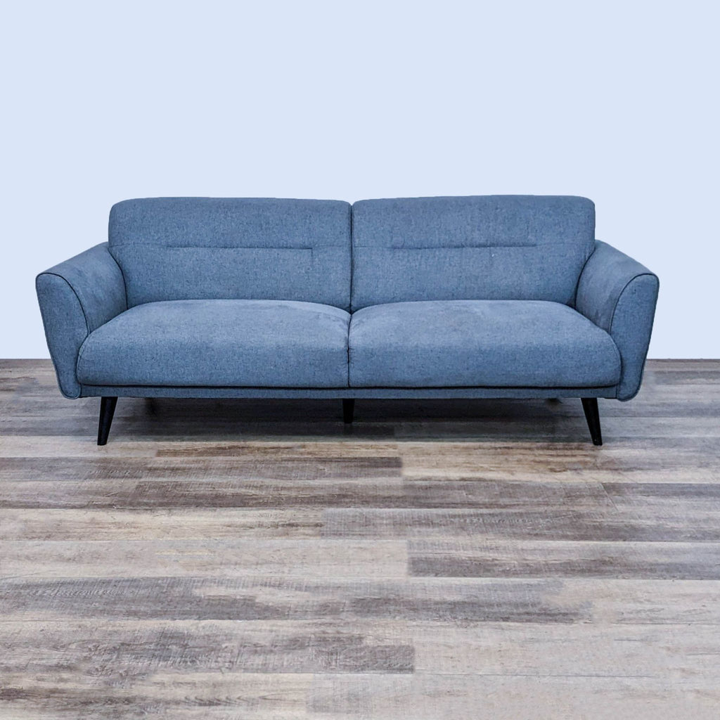 Sleek 84" blue sofa with tapered black legs, showcasing modern design.