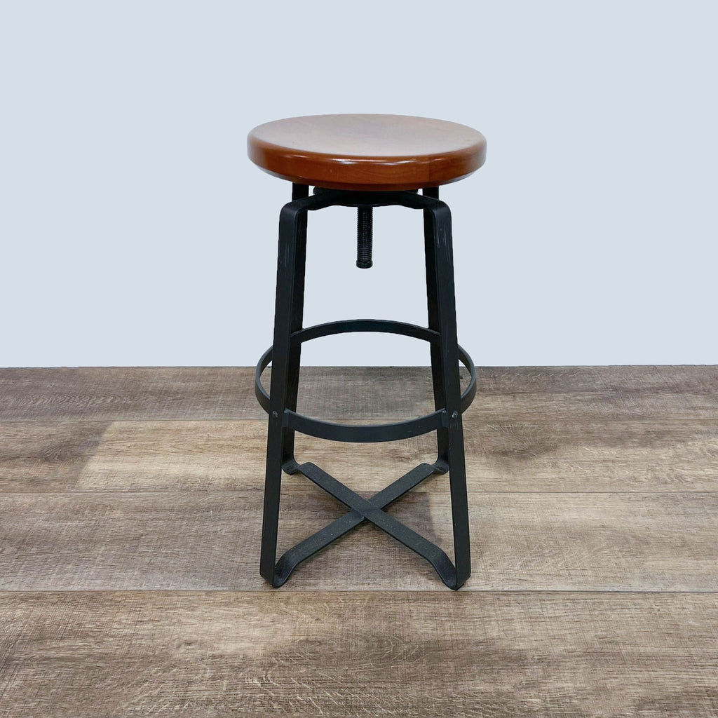 Industrial-style stool with wooden seat, adjustable metal frame.
