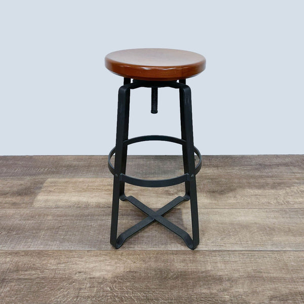 Industrial-style stool with wooden seat, adjustable metal frame.