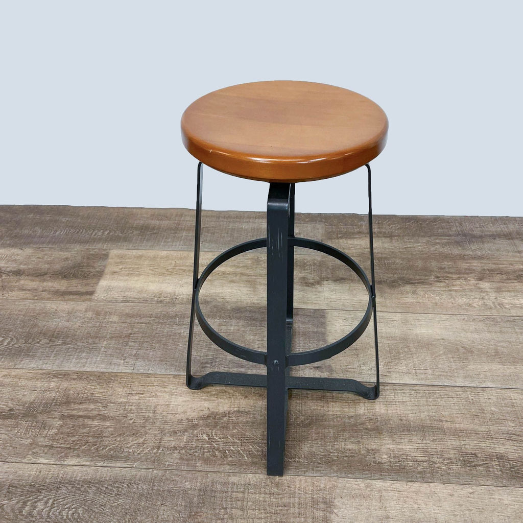 West Elm stool featuring a round wooden seat and metal frame.