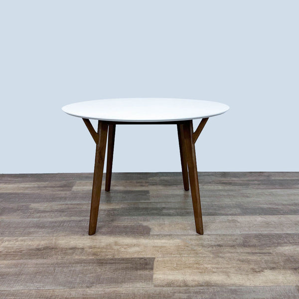Wegmans Furniture dining table with a white round top and wood legs in Scandinavian style.