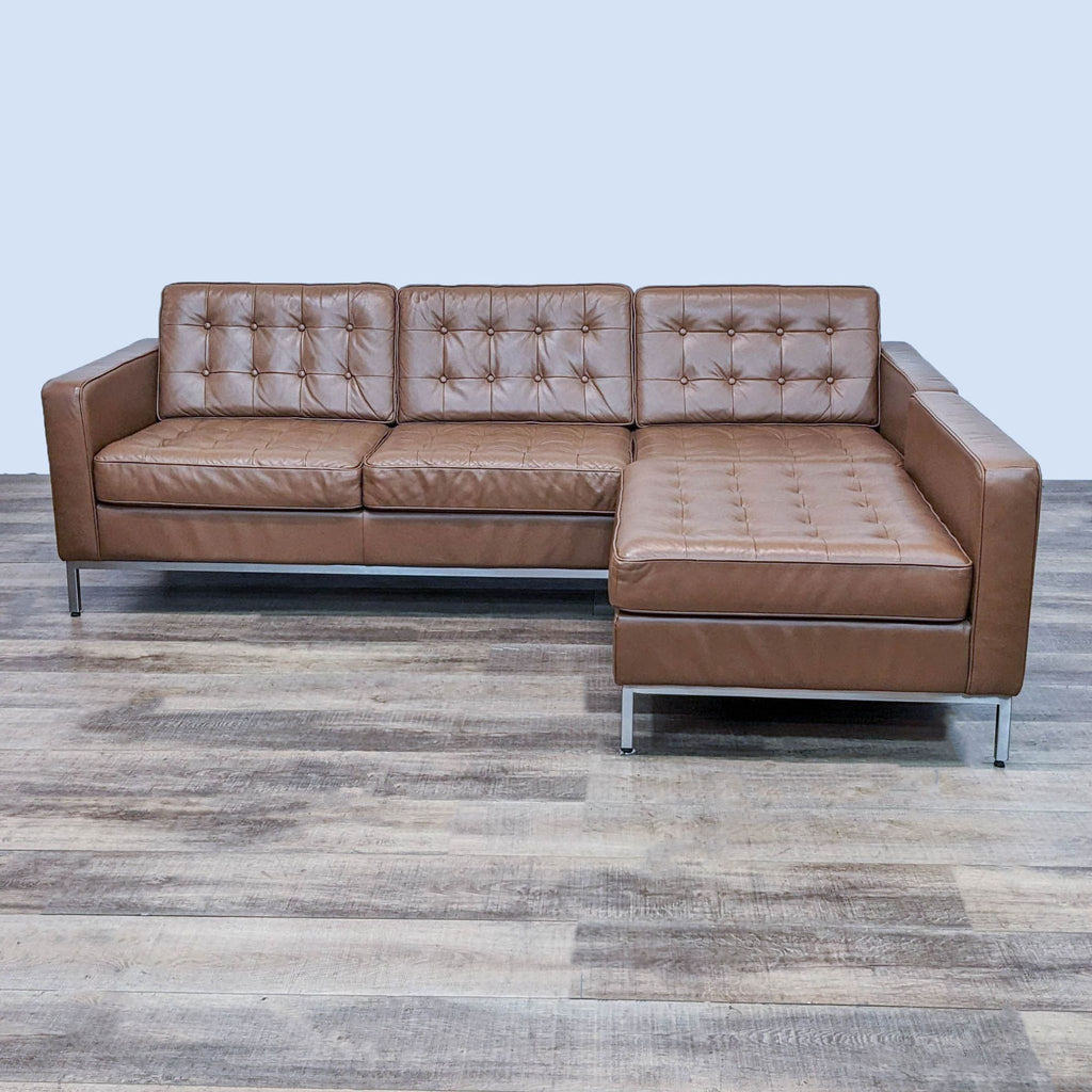 Brown tufted leather sectional with reversible chaise and chrome legs, seen from front.