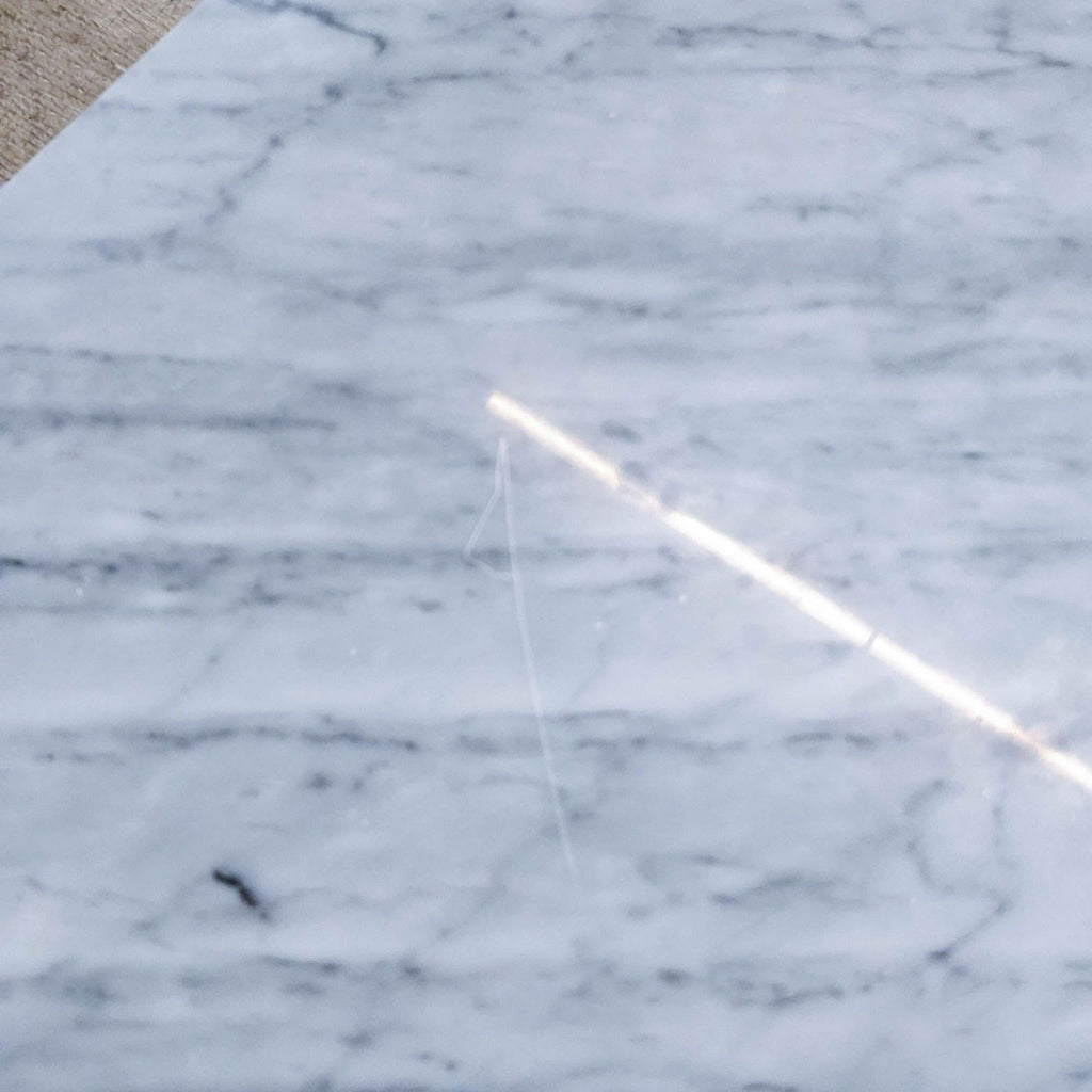 Detail of marble table surface with scratches and light reflection.