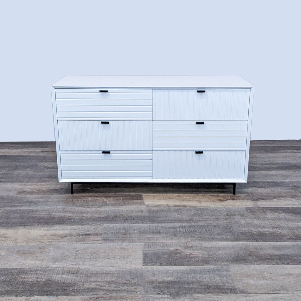 White dresser with horizontal and vertical ridges and black handles, on black metal legs by VIG Furniture.