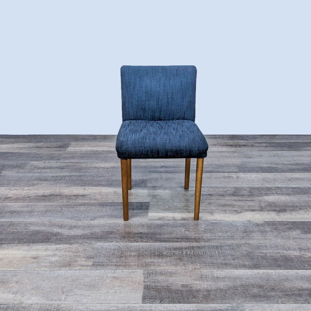 Front view of the Ellis side chair with navy upholstery and wooden legs on a wooden floor.