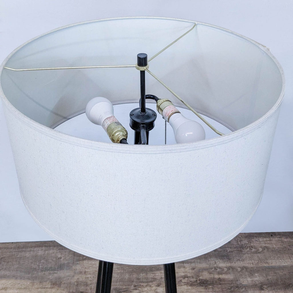 Close-up of a Reperch lamp's interior, showing two light bulbs and a metal support.