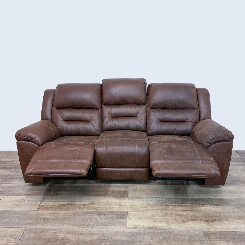 Reperch saddle brown dual-reclining sofa with extended footrests and plush seating.