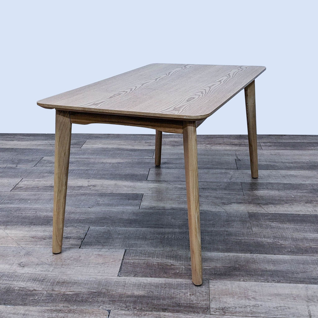 Natural finish dining table by Reperch in mid-century modern style with rounded edges.