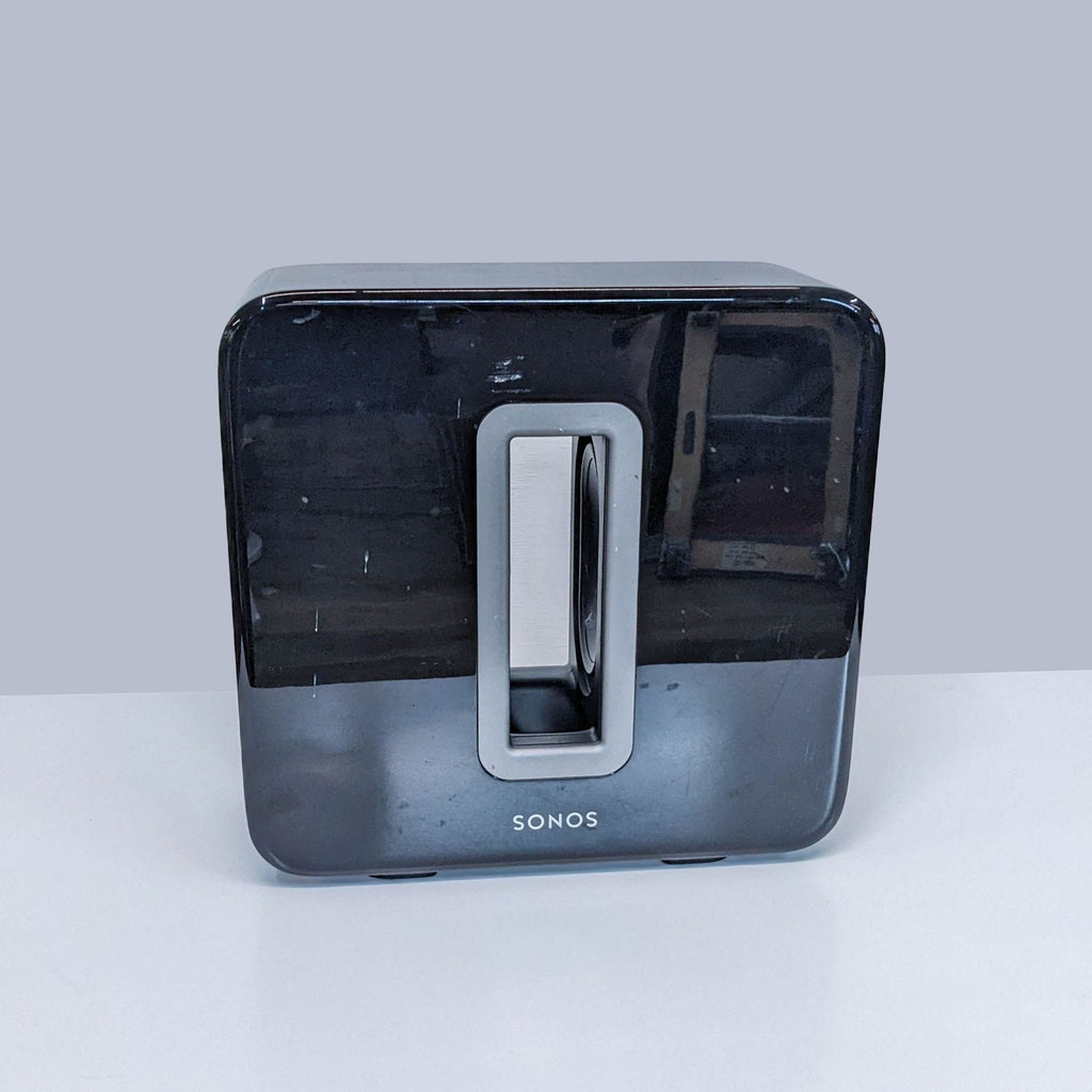 Sonos Subwoofer in glossy black with front handle, placed on a white surface.