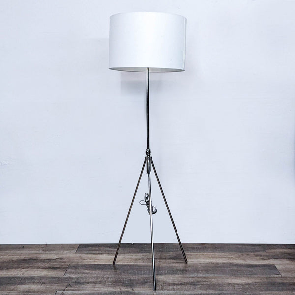 Tripod floor lamp with a white shade by Reperch.  