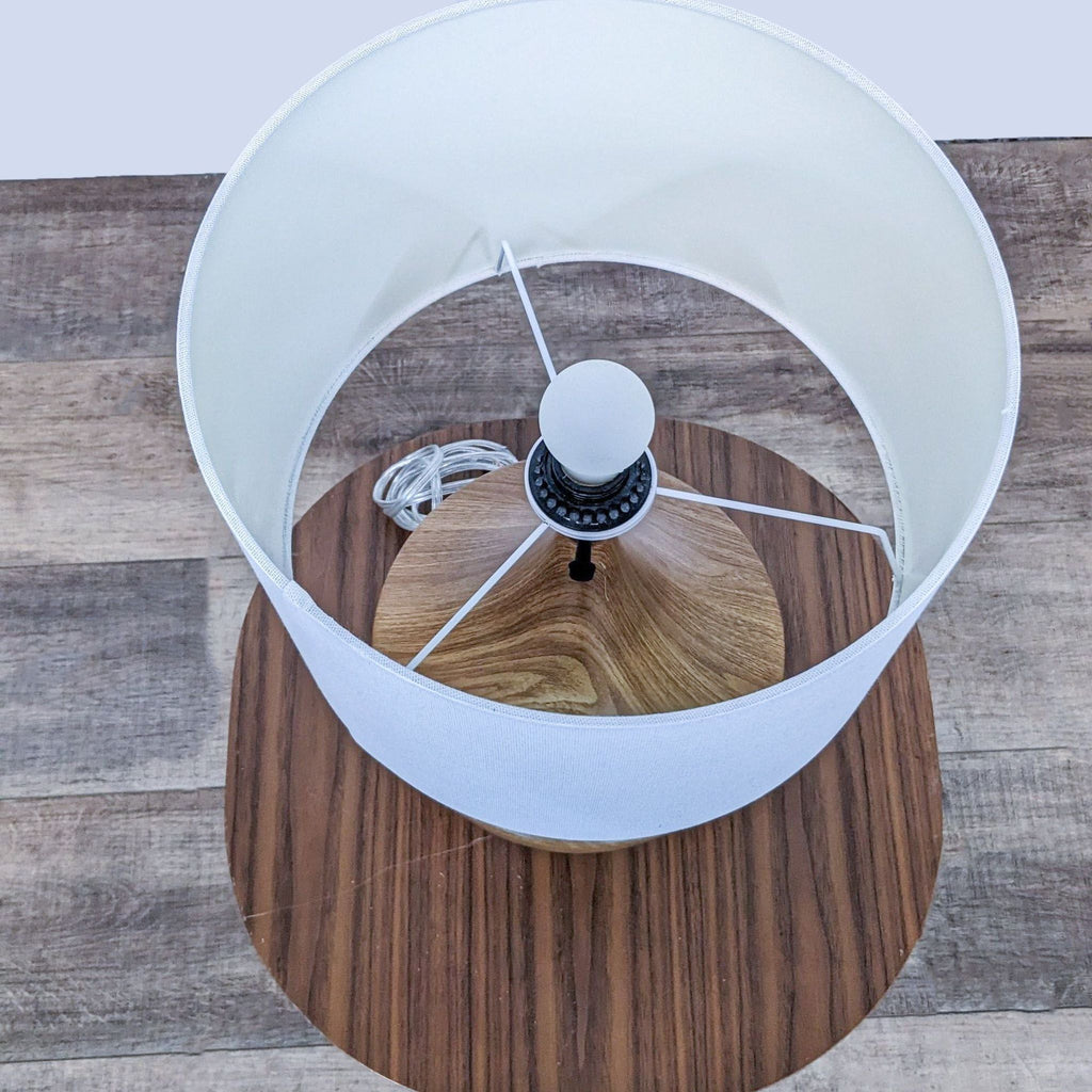 Top view of Reperch lamp, wooden base, white shade, and visible bulb.