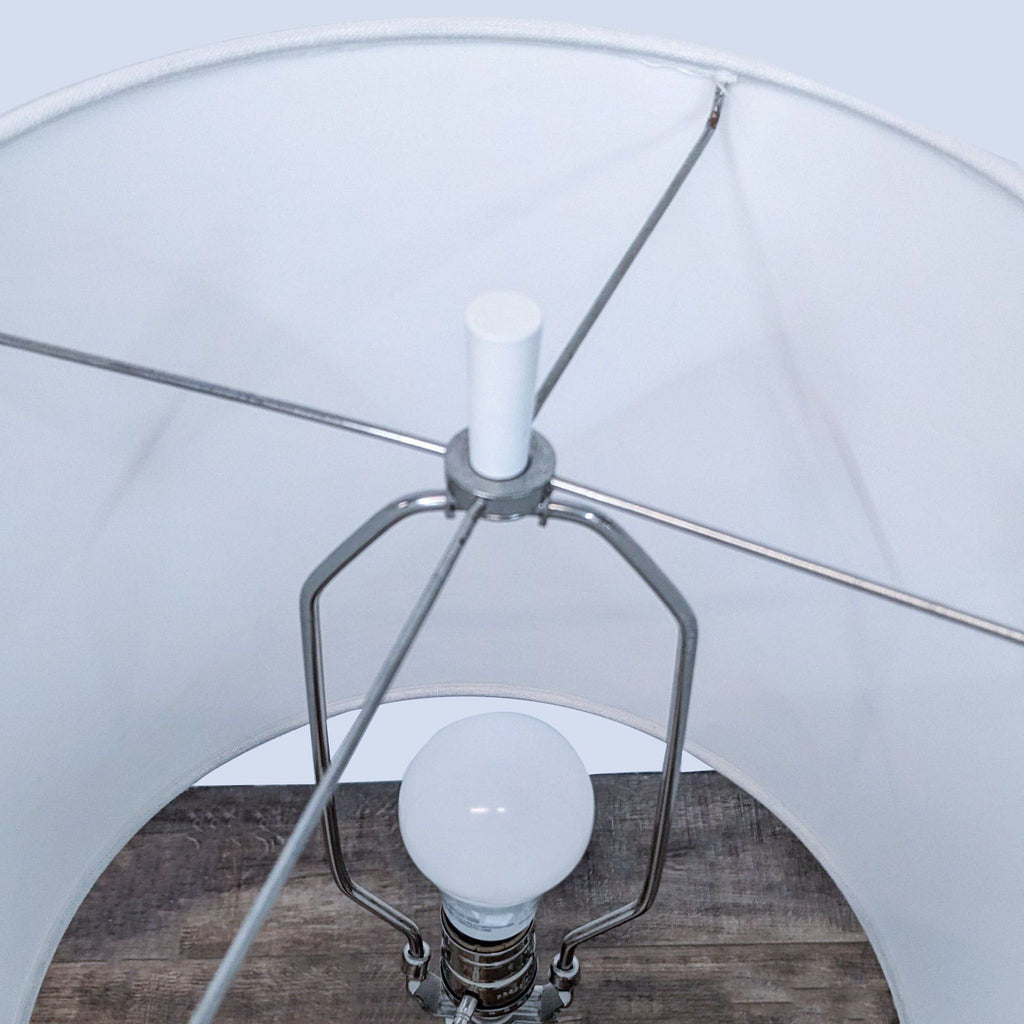 View inside the white lamp showing a light bulb and metal frame.