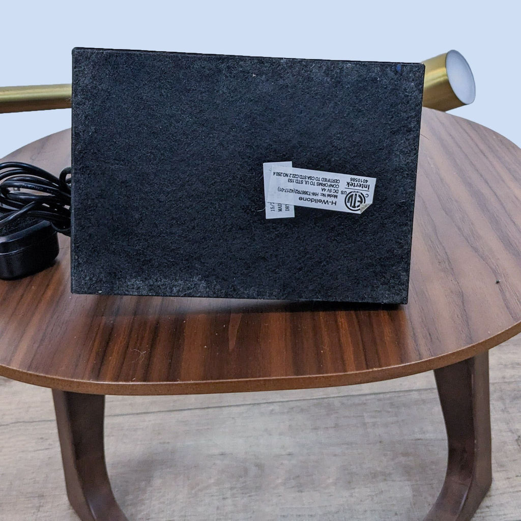 Bottom view of Reperch lamp on table, showing product info.