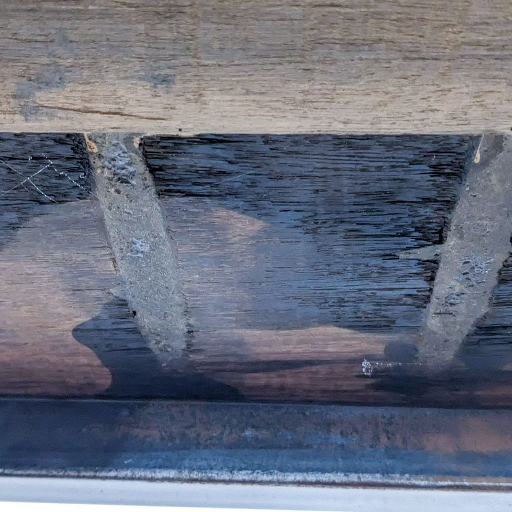 Close-up of the metal and wood texture of the bookshelf shelf.