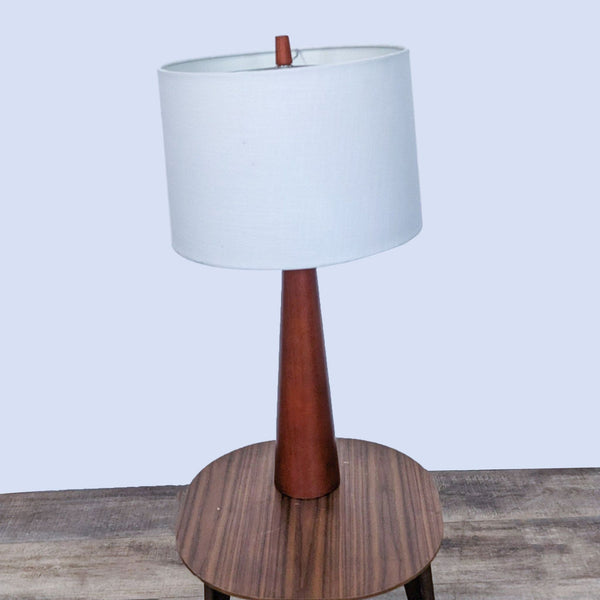 Reperch table lamp with a wooden base and white fabric shade.