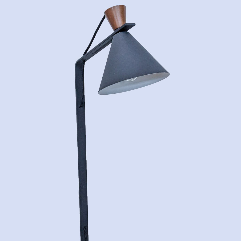 Close-up of Reperch lamp's cone shade and slender black stand against a light background.