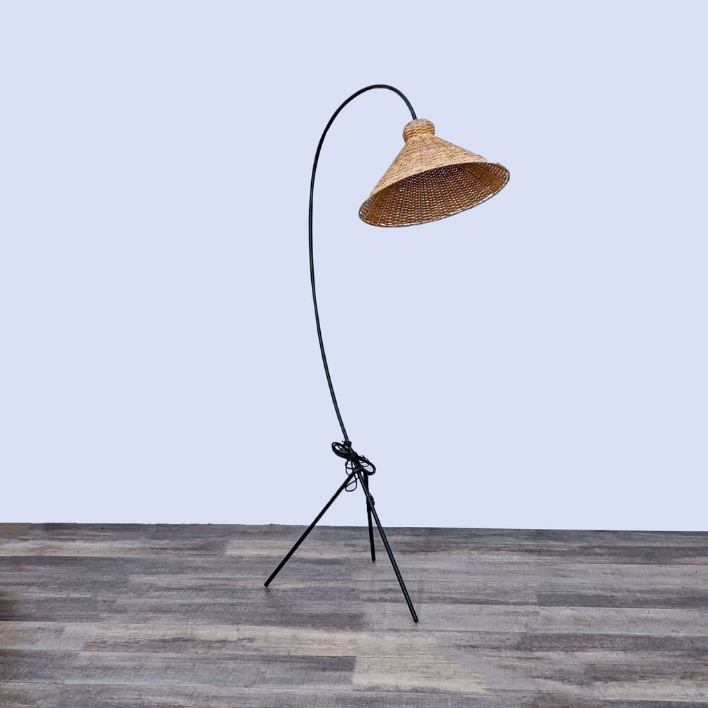 Stylish lighting piece with a curved frame and rattan shade by Athena Calderone.