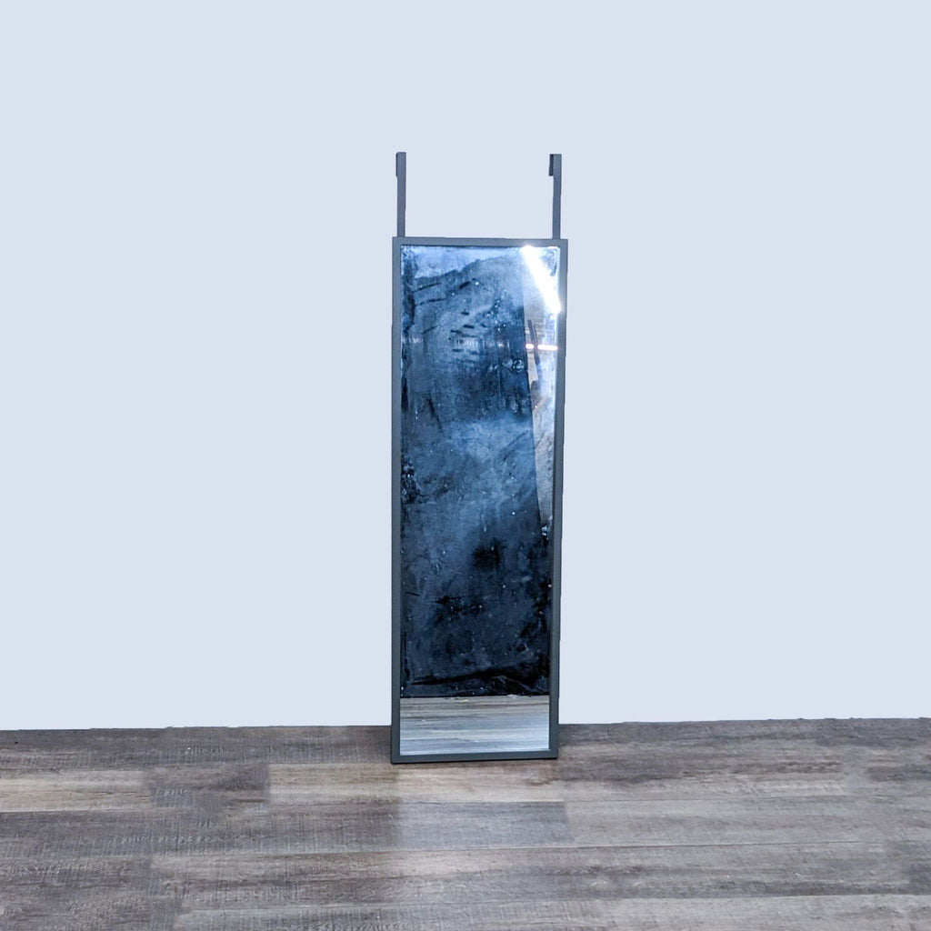 Framed full-length mirror from Crate & Barrel with metal hangers for door mounting.