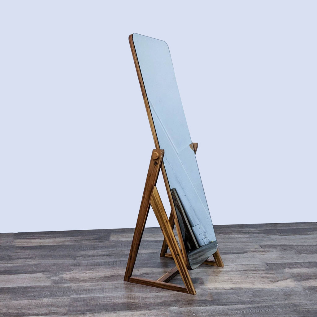 Side view of CB2 Drommen Mirror, showcasing wooden intersecting legs.