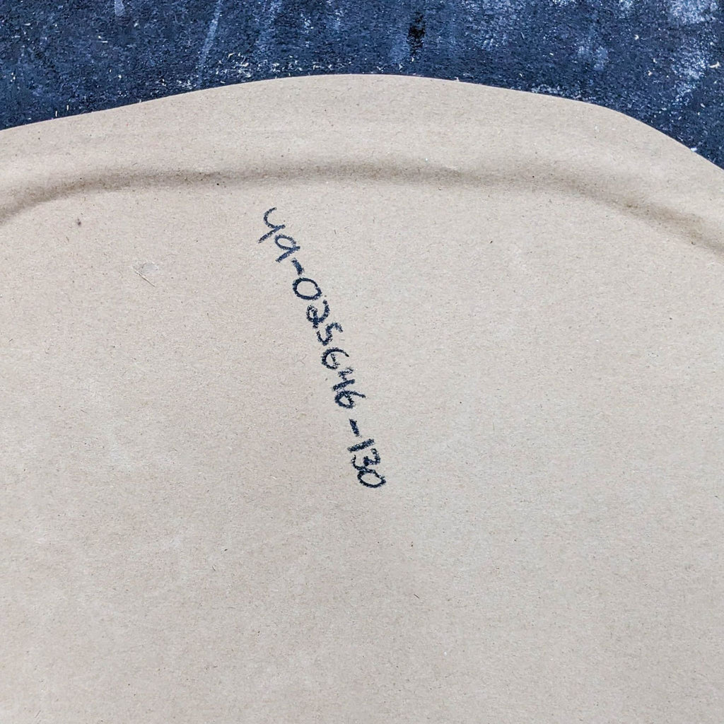 Backside of mirror showing a handwritten serial number on beige backing.