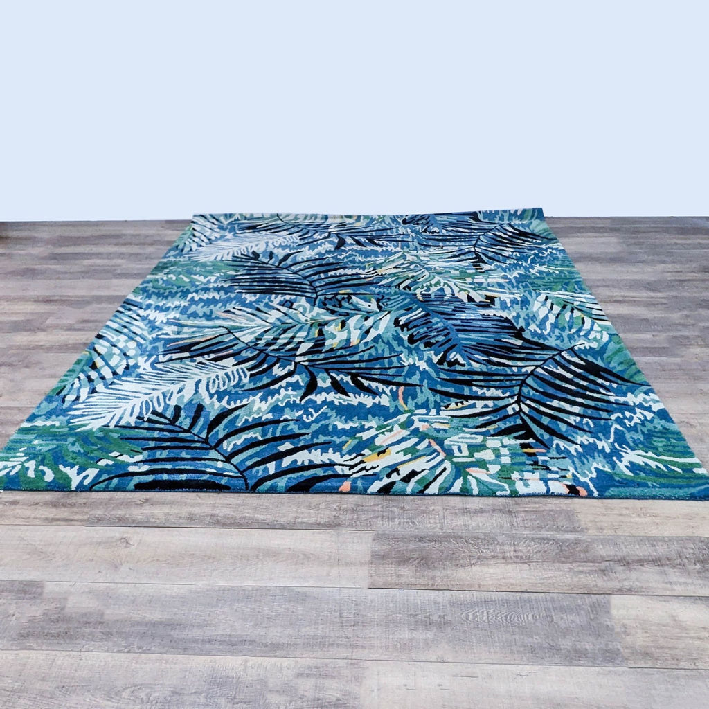 The Midnight Jungle rug by CB2 with tropical leaf patterns in blue and green hues.