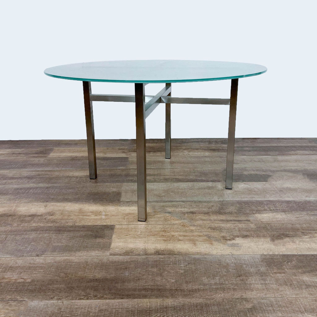 Modern dining table by Room & Board featuring a metal cross brace and glass top.