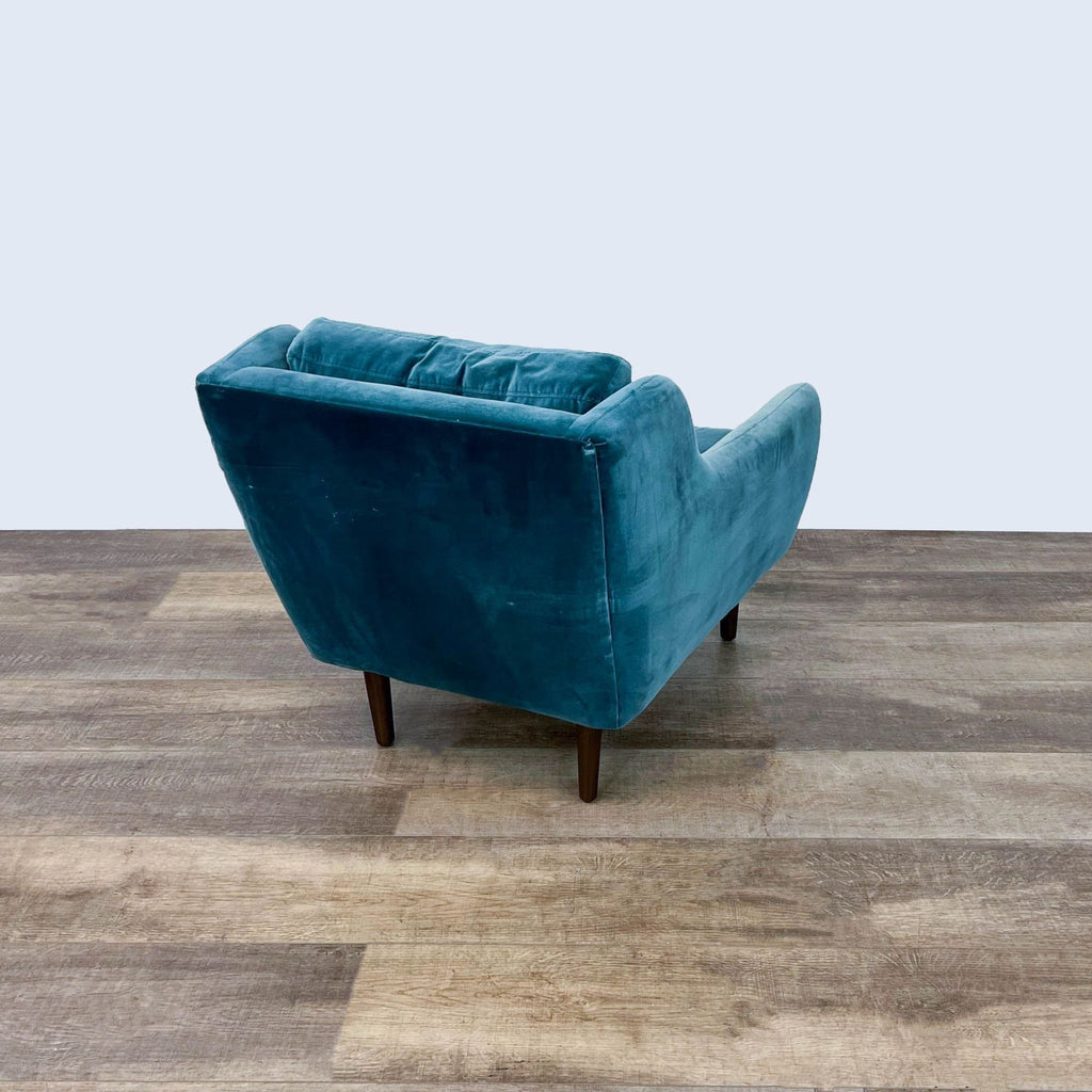 3. Rear view of Article Matrix lounge chair, highlighting its blue velvet fabric and sturdy wooden frame.