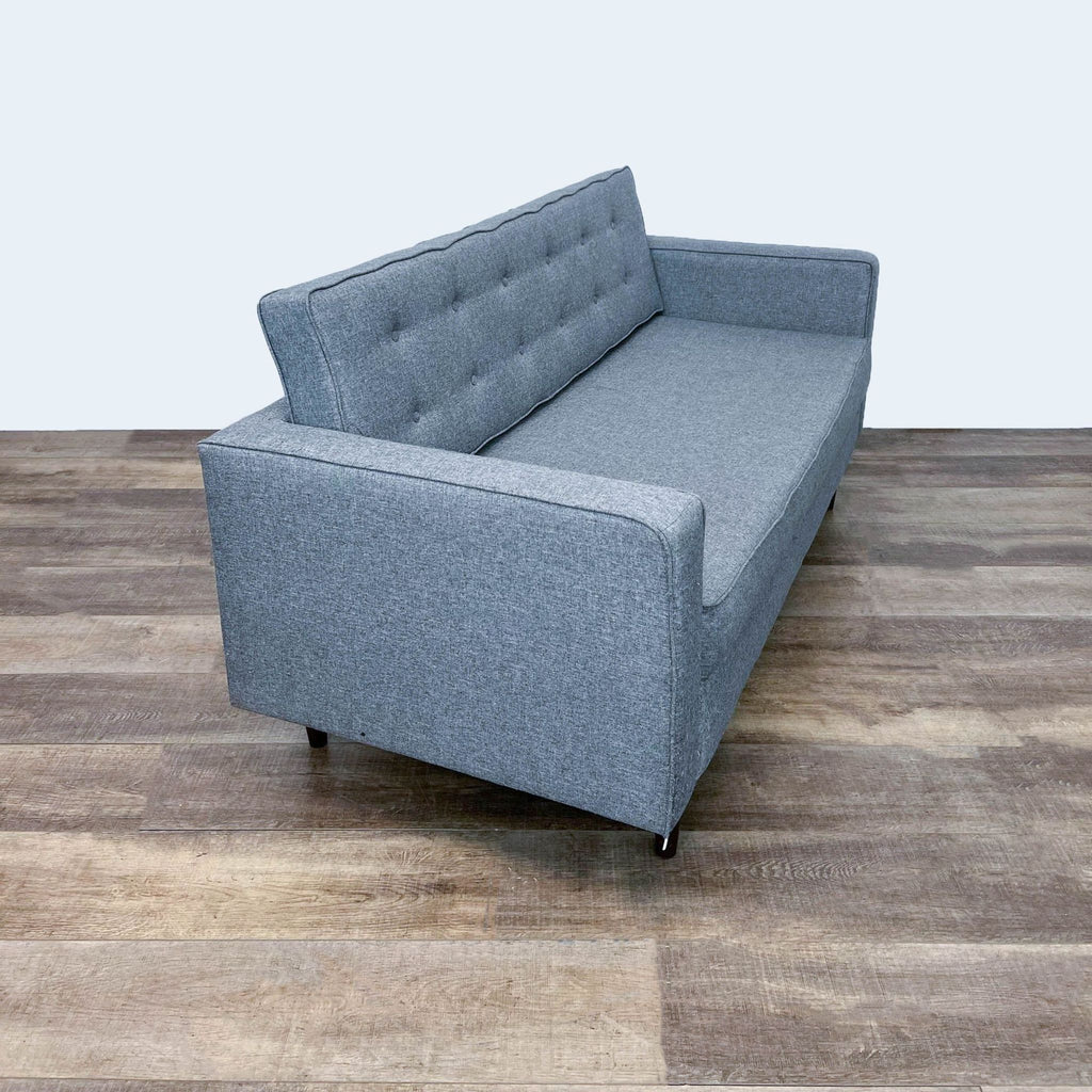 Modern tufted sofa with dark finish legs and firm cushioning.